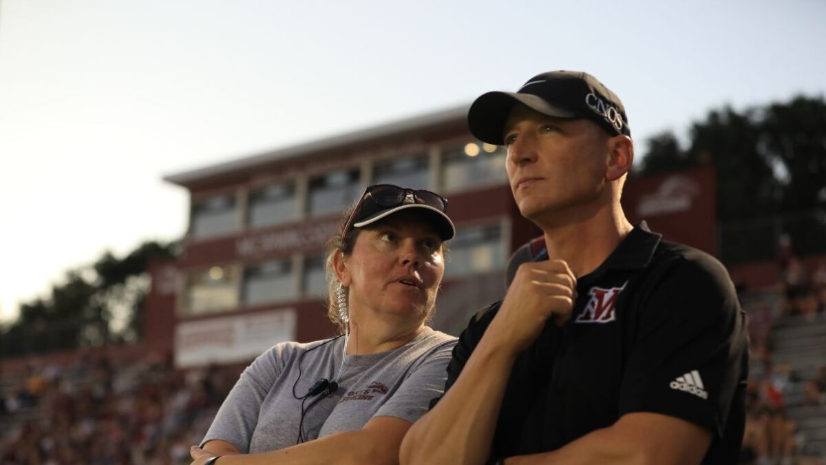 Katy Burford and Dr. Ryan Meis oversee a football sideline