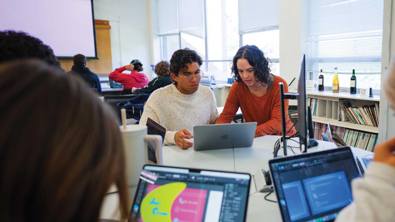 graphic design professor working alongside a student