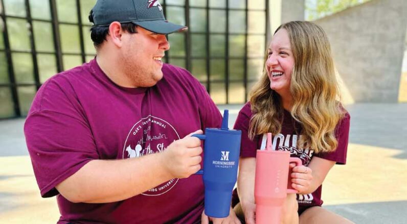 Two students laughing holding HydroJug water bottles
