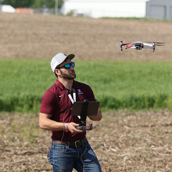 Student Flying Drone In Field