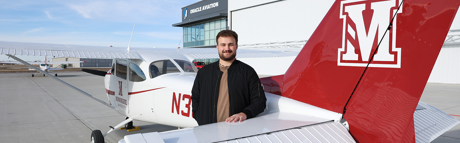 Student Standing In Front Of Morningside Plane