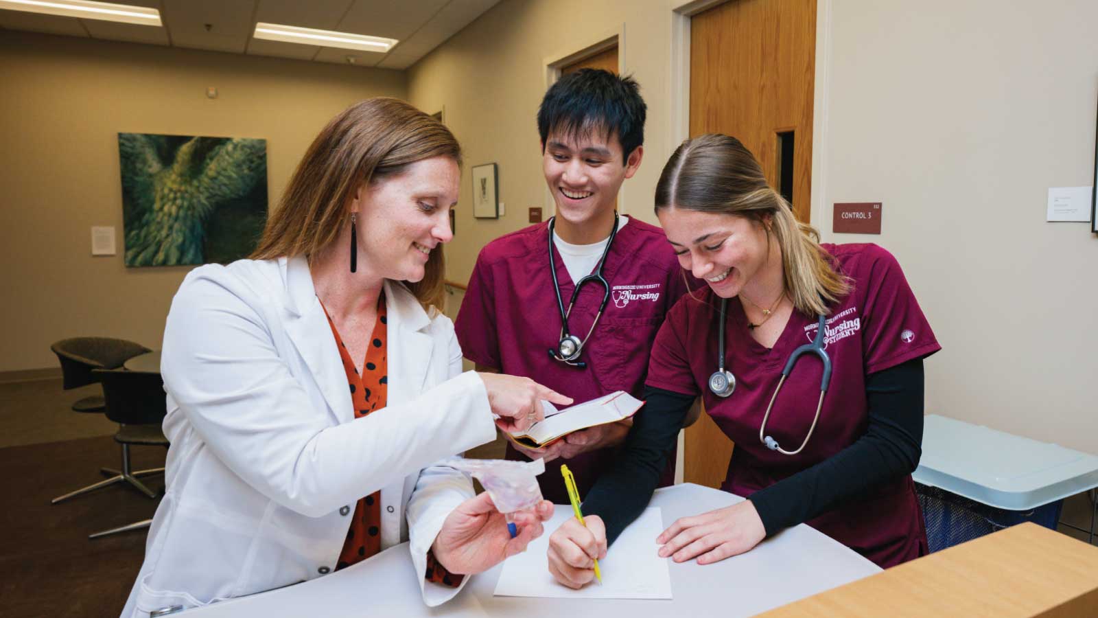 two nursing students with a professor