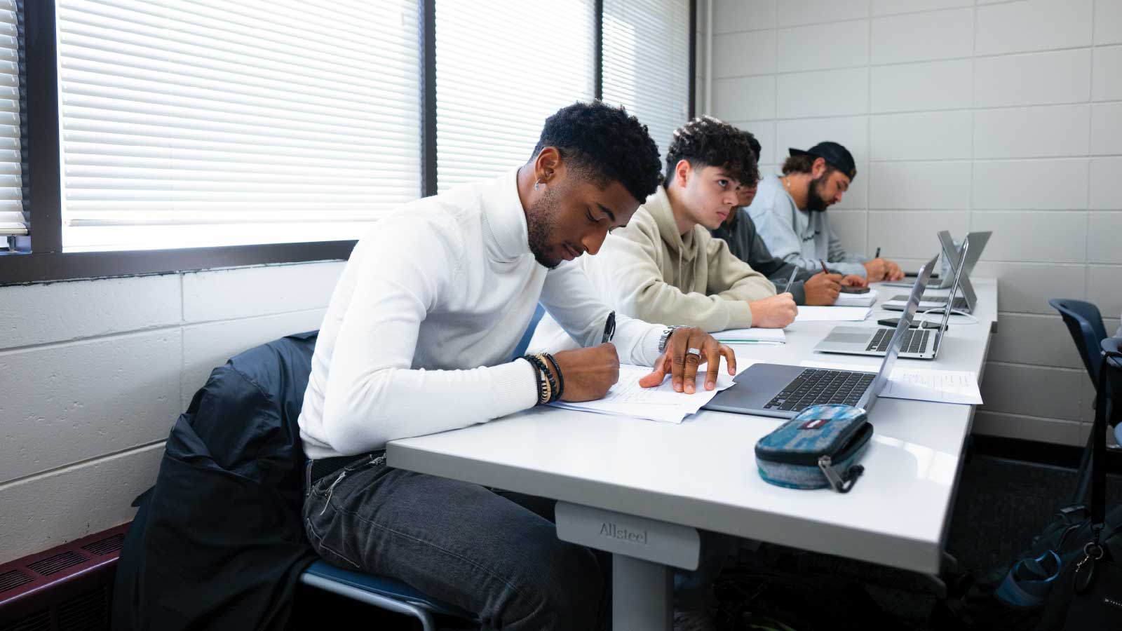 students studying at a table in classroom